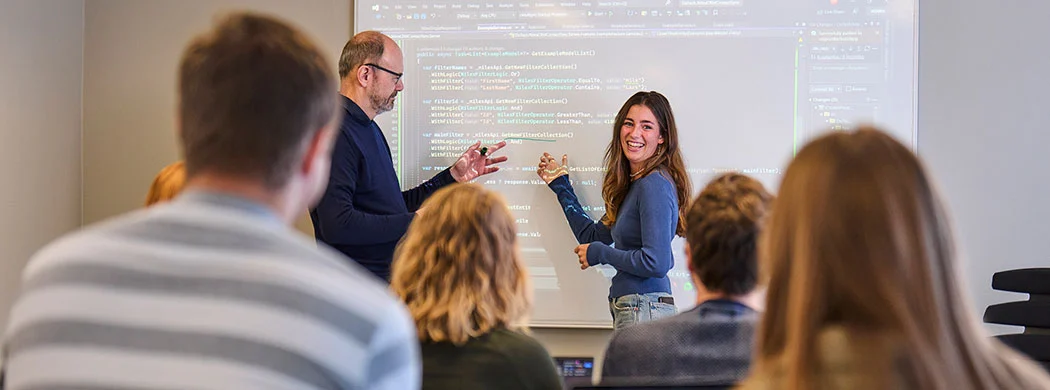 Multimediedesigner studerende arbejder på laptop med kreative designprojekter, digitale grænseflader og moderne udviklingsværktøjer i et inspirerende studiemiljø